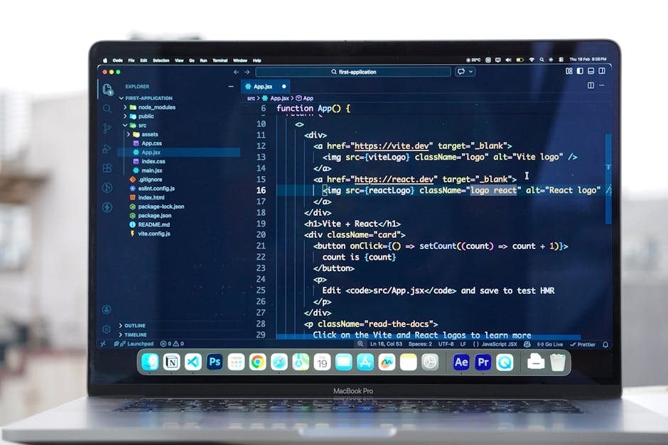A close-up view of an open MacBook Pro laptop placed on a flat surface outdoors, showing a code editor displaying a programming script with HTML tags and JavaScript functions. The laptop has a sleek s